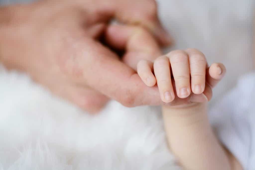 baby holding it s parent finger 733880